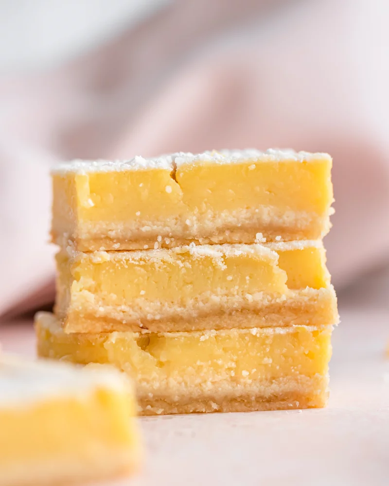 Stack of lemon bars on a pink background