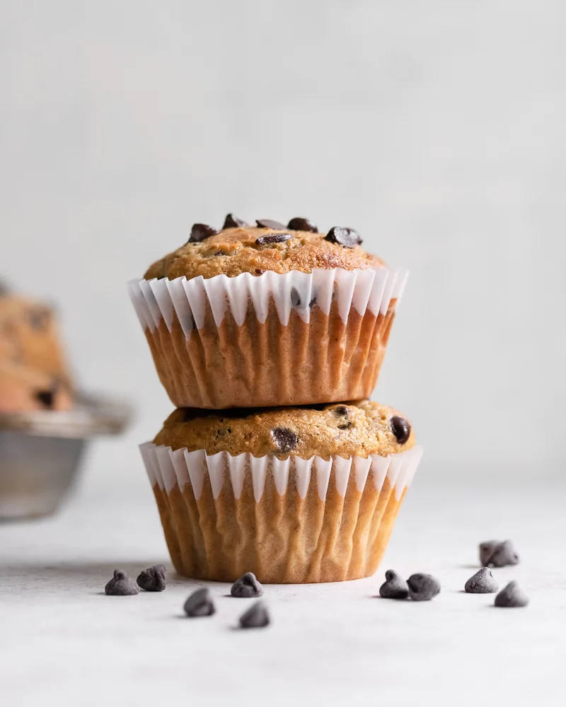 A stack of muffins in white baking cups.