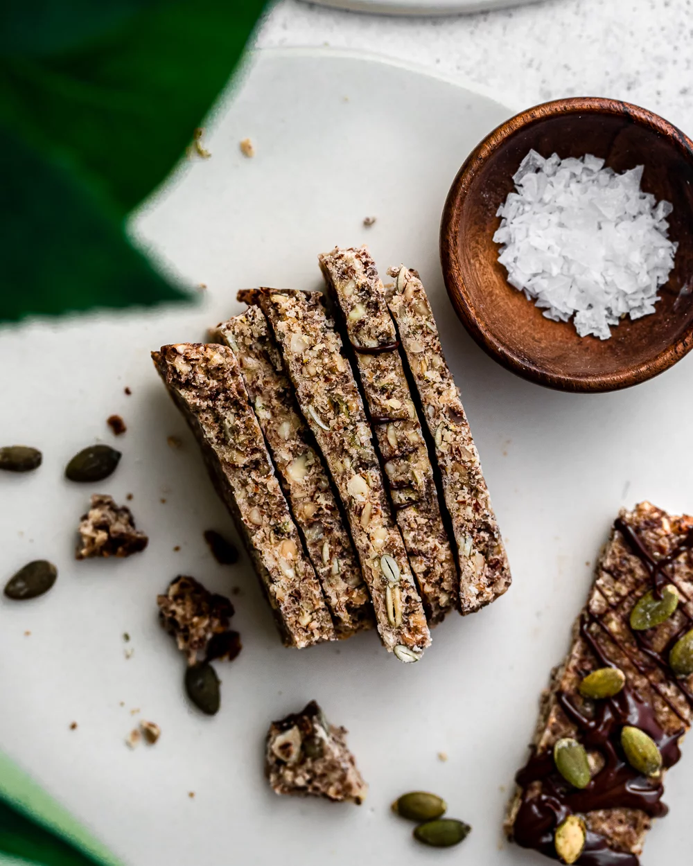 A side view of granola bars topped with chocolate and pumpkin seeds